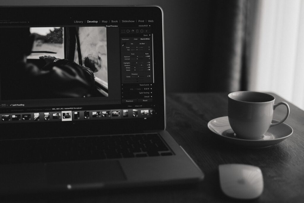 Minimalist black and white photo of a laptop with coffee. Ideal for home office themes.